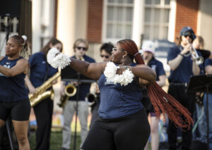 Photo of student at the event including girl with pom-pom and some playing instruments