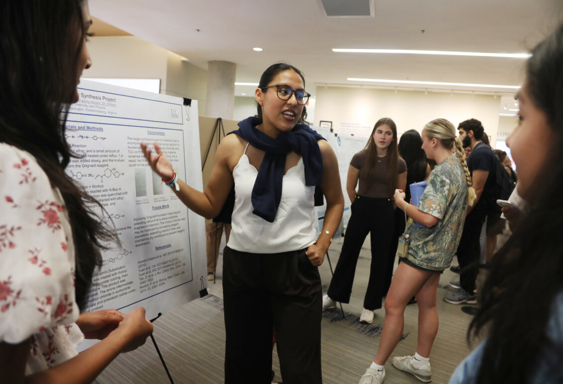 A student presents her work on a poster