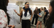 A student presents her work on a poster