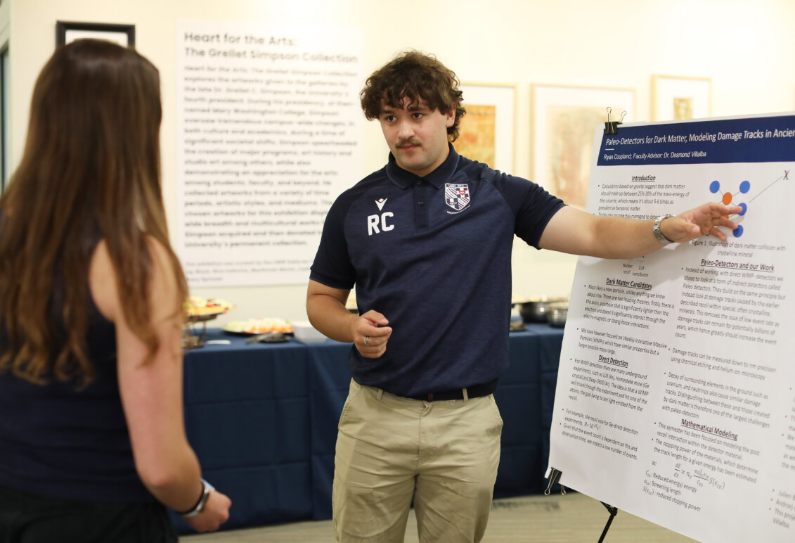 A student presents his work on a poster