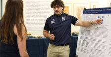 A student presents his work on a poster
