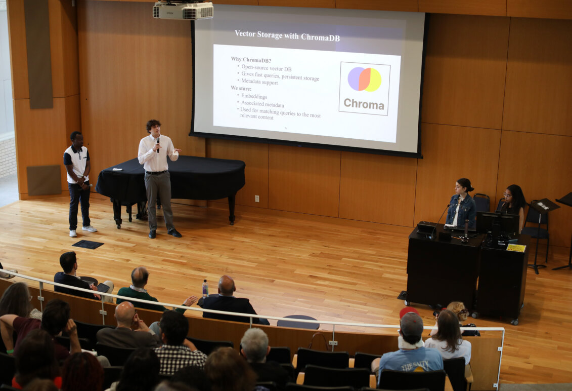 Student group onstage for a presentation for  the AI symposium