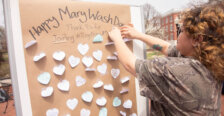 Students stick messages on a board that says Happy Mary Wash Day.