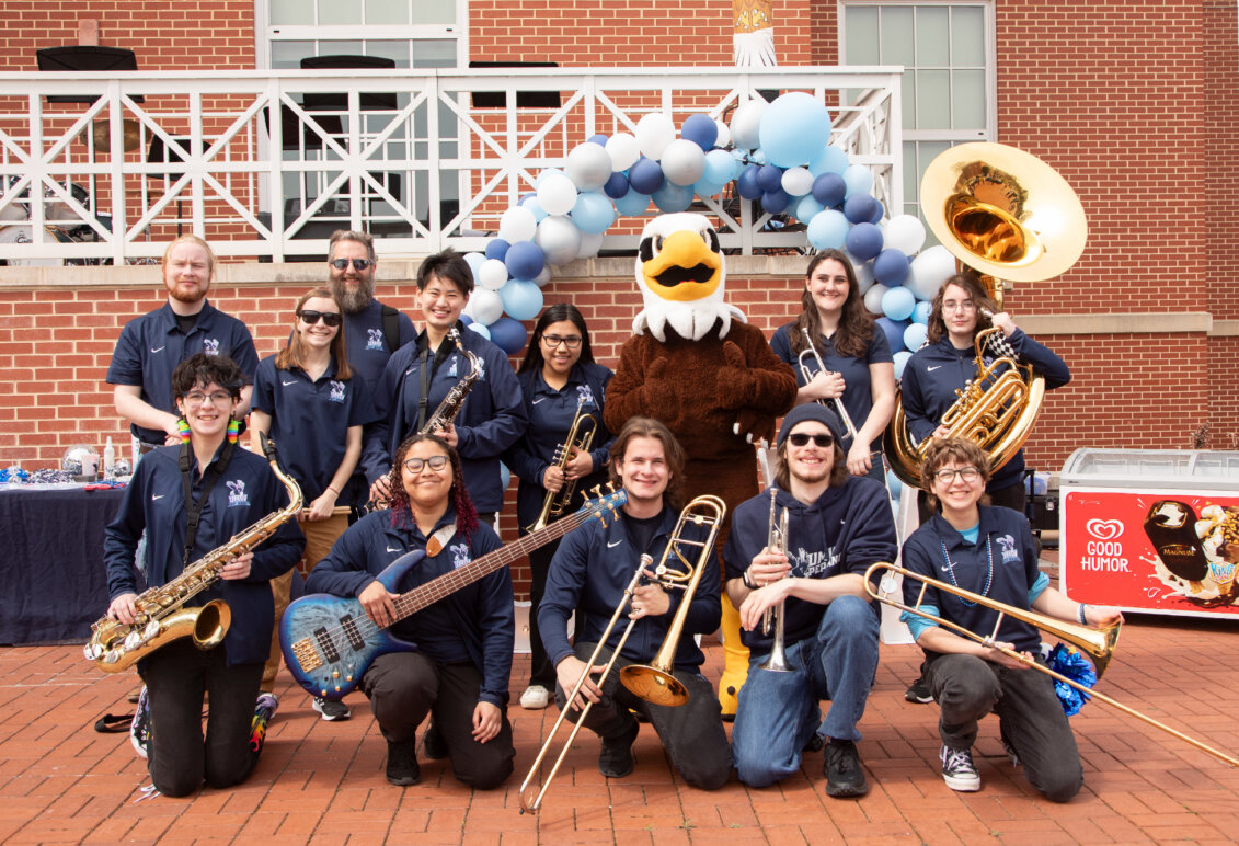 The UMW pep band with their instruments and UMW mascot Sammy D. Eagle.