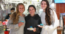 Three students in the UMW Dining facility holding blue desserts.