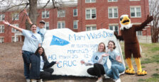 Students with the Spirit Rock that has information about Mary Wash Day. UMW mascot Sammy D. Eagle stands on the right.