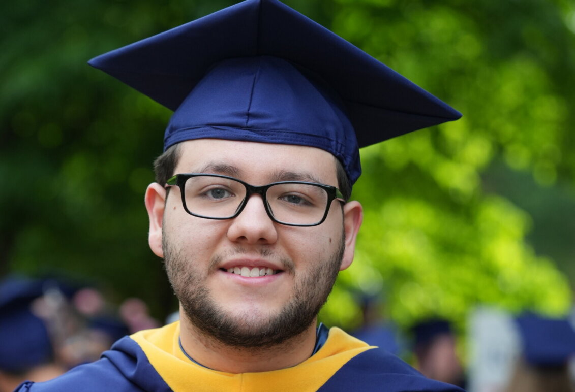 A graduate wearing blue and gold