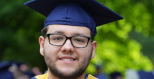 A graduate wearing blue and gold
