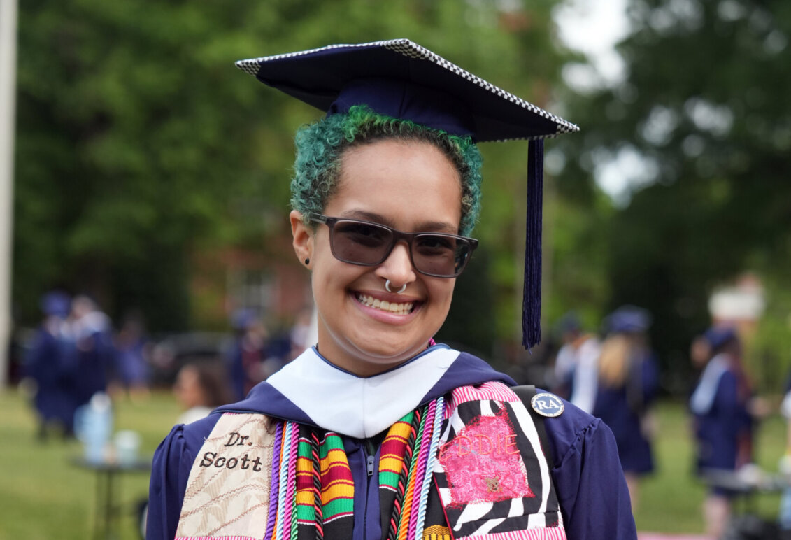 A graduate wearing colorful stoles