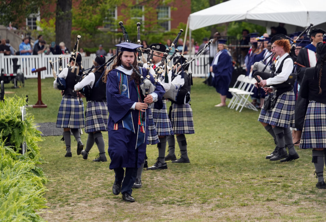 People dressed in kilts and playing bagpipes at a college graduation