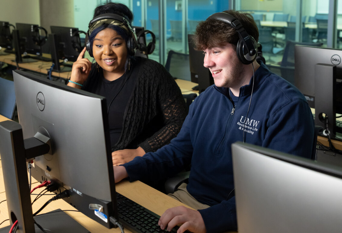 Raven Jackson and Matthew Clinton sit in a classroom behind a computer screen with headsets on