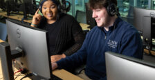 Raven Jackson and Matthew Clinton sit in a classroom behind a computer screen with headsets on