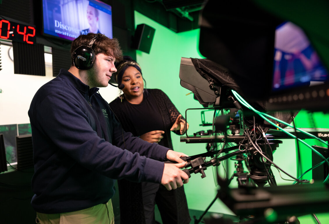 Clinton and Raven Jackson behind the camera with headsets on