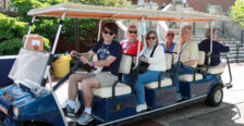 A student-led golf cart tour of campus stops in front of Lee Hall.