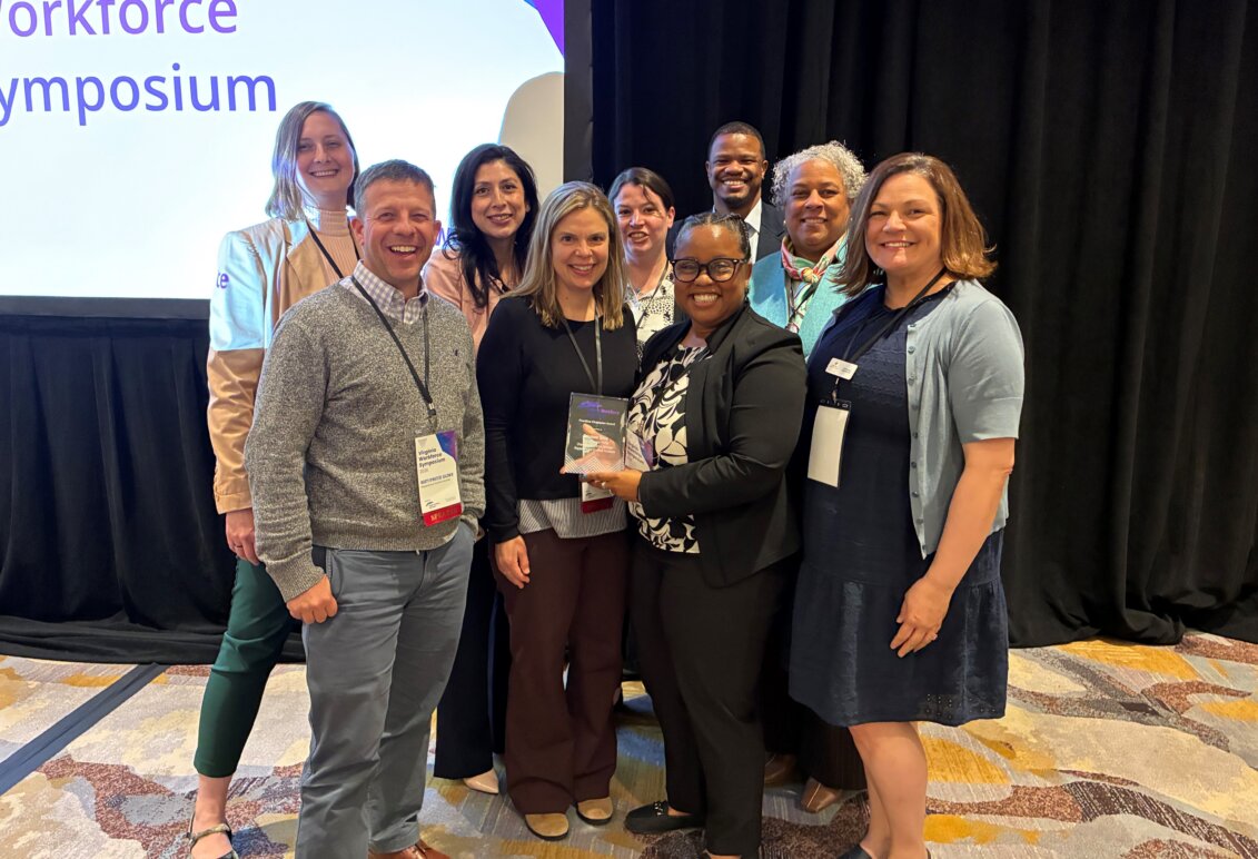 Bywaters-Baldwin poses with a group of people from Rappahannock Goodwill at the Virginia Workforce Symposium