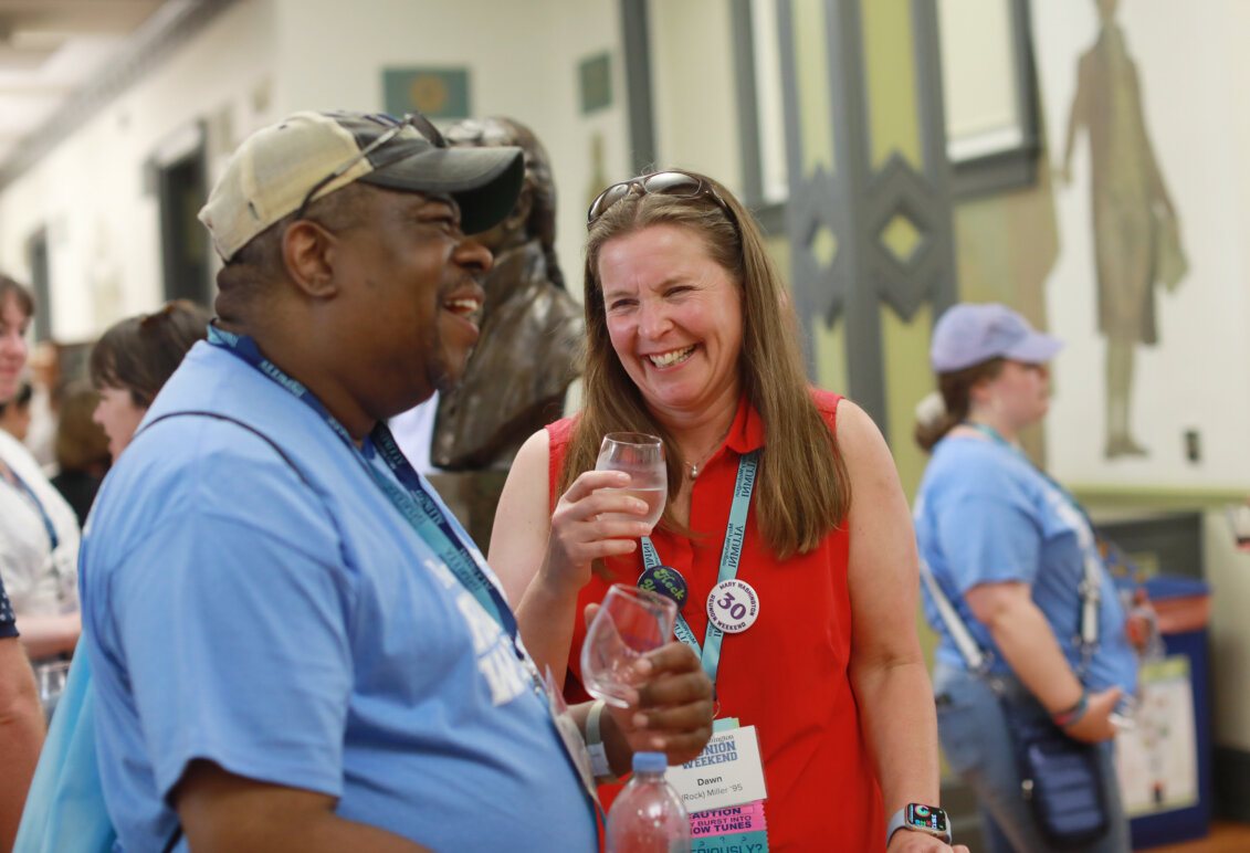 Two alumni laugh and enjoy wine tasting at the Virginia wine, beer, and cider tasting during Reunion Weekend.