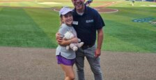 Marty Bywaters-Baldwin stands with daughter at a Fred Nats game