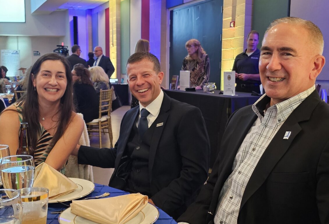 Marty Bywaters-Baldwin at a dinner table with his wife Sara and a colleague