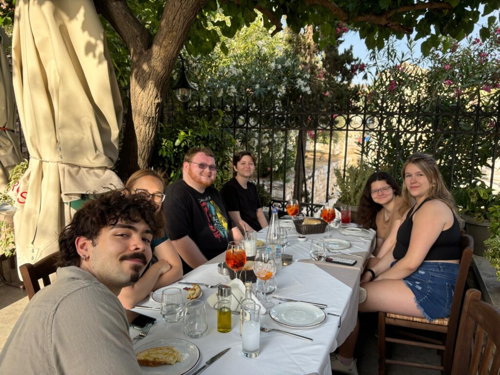A group of UMW students dining outdoors in Greece.