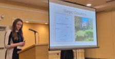 Bowman at the podium with a presentation on the screen beside her