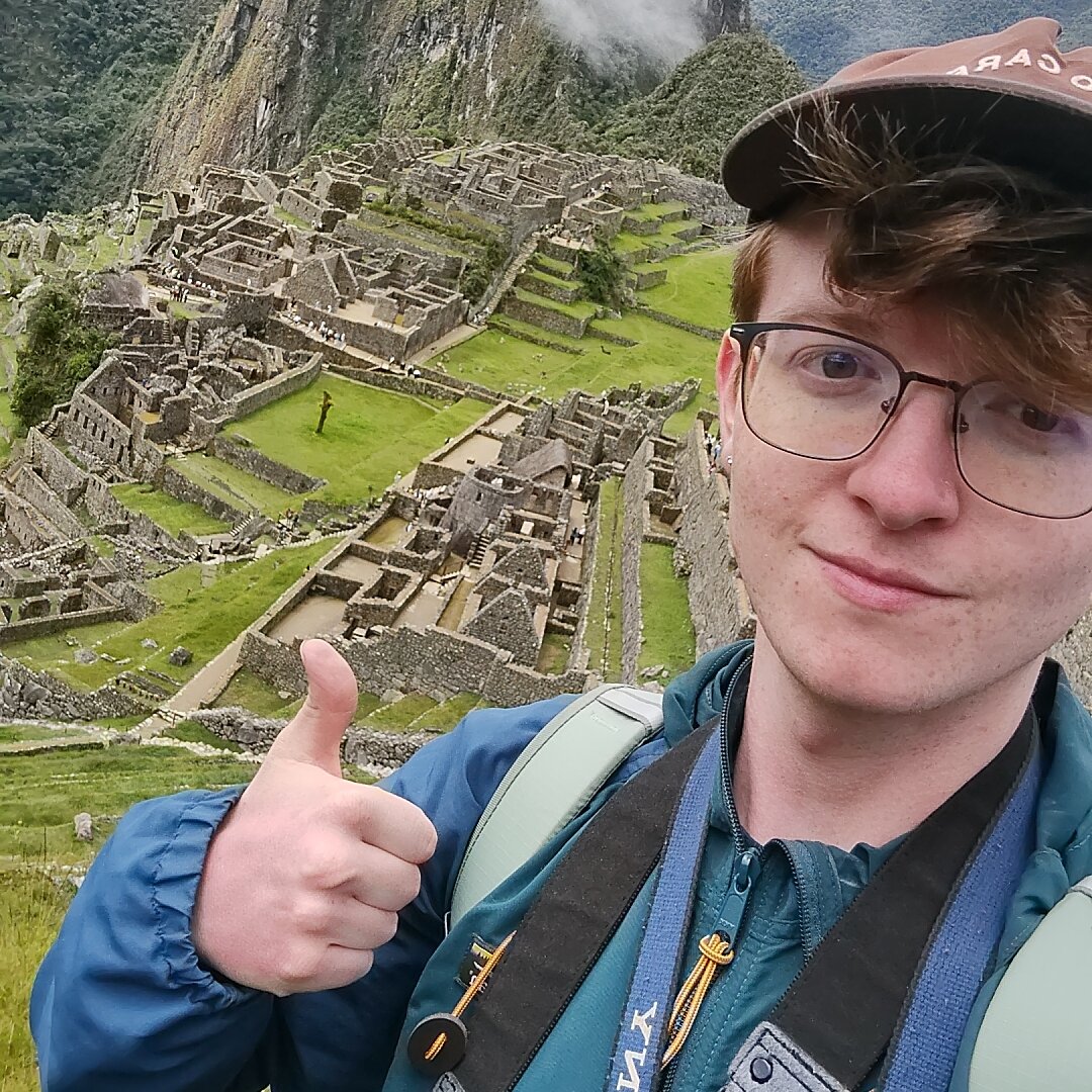 Bauer giving a thumbs up with Machu Picchu in the background.