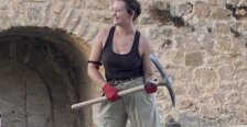 Bowman holding a pick ax on an excavation in Spain
