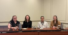 Bowman and three other panelists pose for a photo while sitting at a table