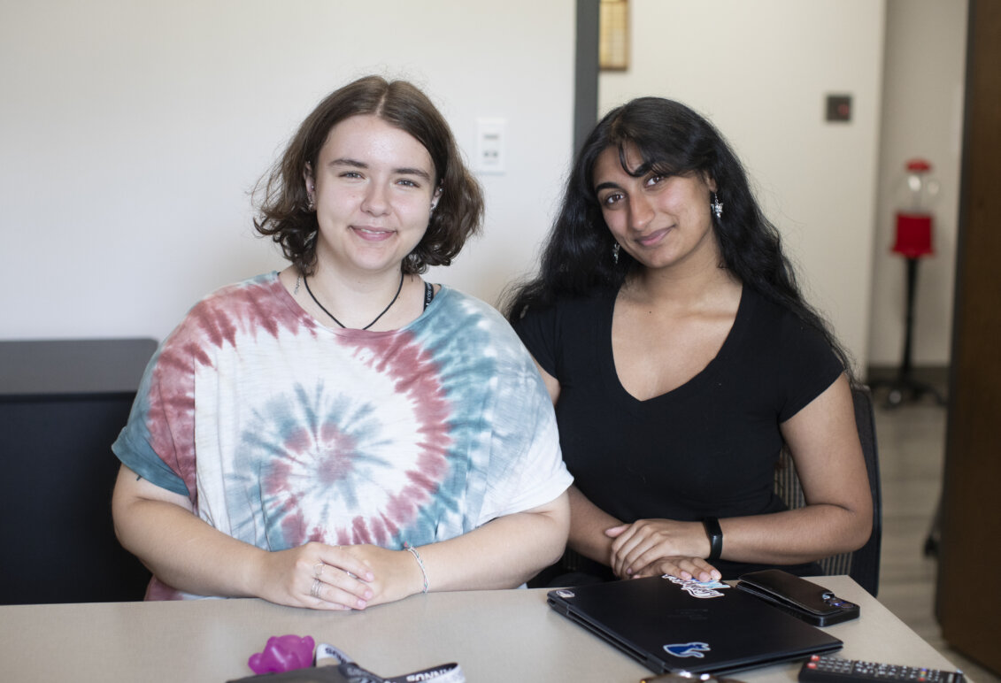 Two students pose together while smiling at the camera.
