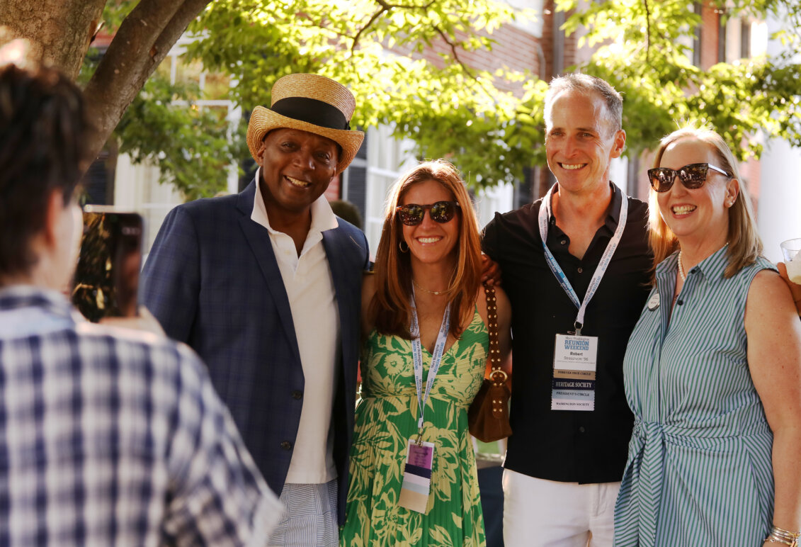 A young alum takes a cell phone picture of Associate Vice President of Student Affairs and Dean of Student Life Emeritus Cedric Rucker '81 and Vice President for Advancement and Alumni Engagement Katie Turcotte with an alumni couple at Brompton.