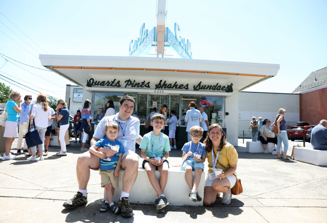 Two alumni parents and their three children eating ice cream in front of Carl's Frozen Custard.