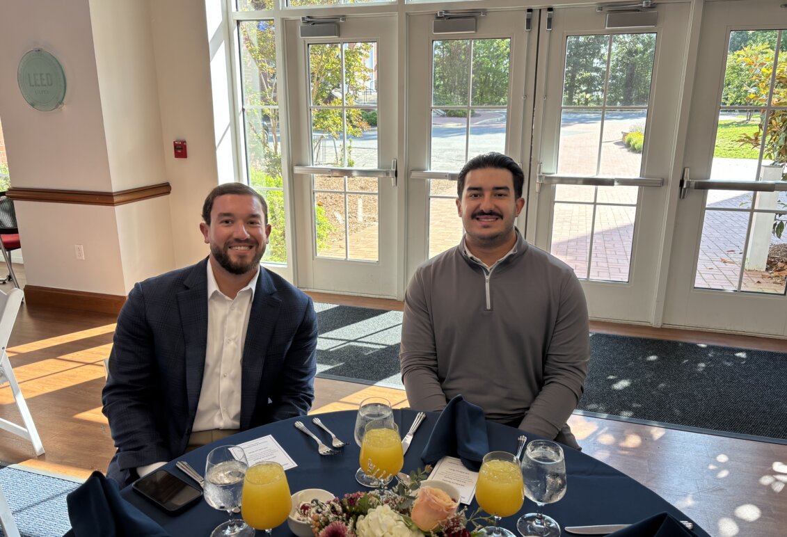 Luis Gavignano and his brother seated at a table in Woodard Hall at the awards event
