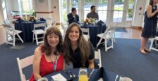 Christina Malave at a table in Woodard Hall with a guest at the Alumni Awards event.