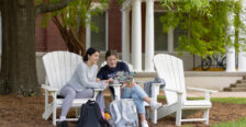 Two students sit in chairs on Ball Circle on UMW campus grounds
