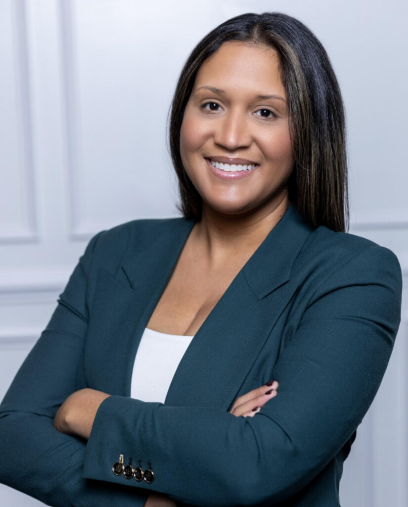 A woman wearing professional clothes and smiling