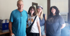 A father, mother and two sisters stand posing for the camera inside the doorway of a college residence hall