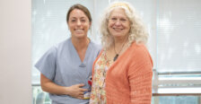 Sabrina Elliott in light blue scrubs smiles next to her former Professor of Biology Deborah O&rsquo;Dell wearing a peach colored sweater. Photo by K Pearlman Photography.