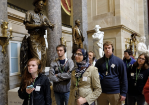UMW students standing in a statuary in a museum