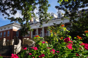 Lee Hall building surrounded by colorful pink and orange flowers and green foliage