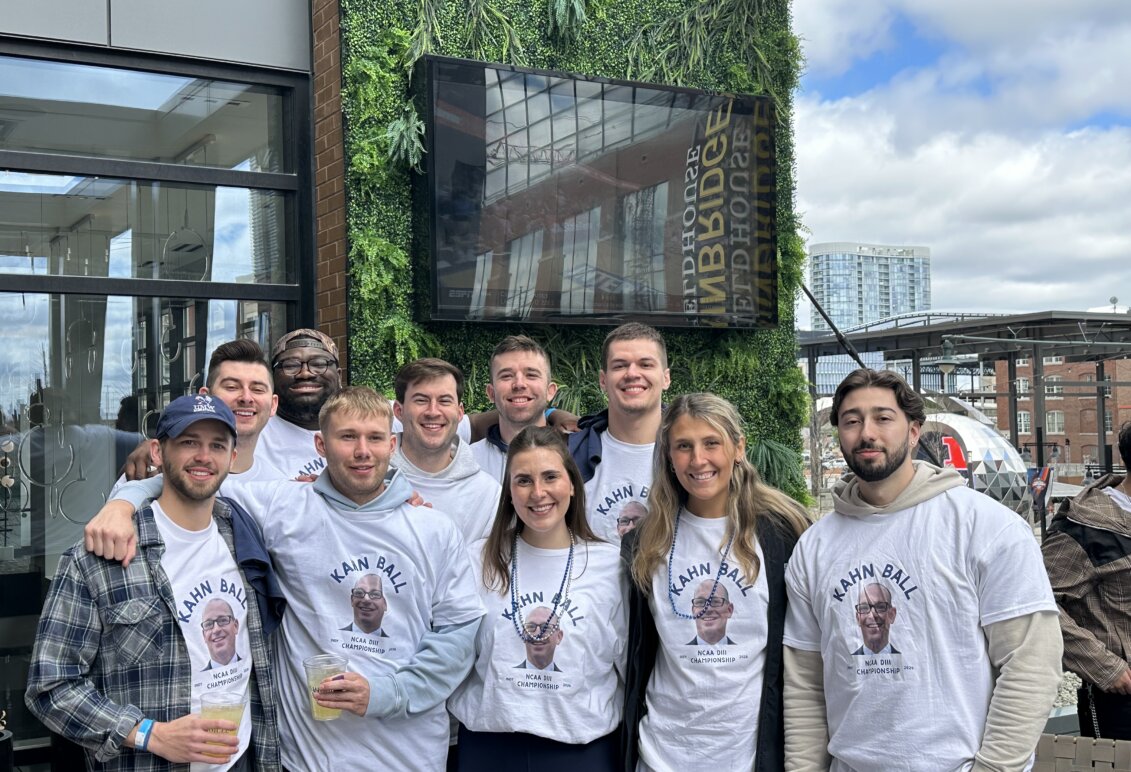 A group of UMW alumni wearing matching Kahn Ball T-shirts outside a brewery.