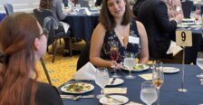 Two students share a conversation over a formal place-setting