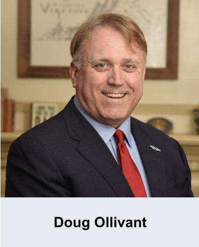 A man wearing a suit and a red tie smiles for the camera