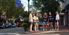 UMW students gather on a sidewalk in downtown Fredericksburg.
