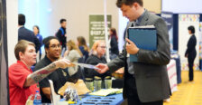 A student takes information from a prospective employer at UMW's Life After Mary Wash Week Career and Internship Fair