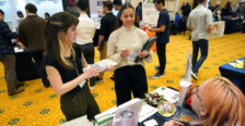 Students approach tables set up at a Career Fair indoors in a building on UMW campus