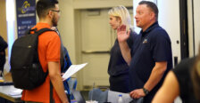 A man speaks with a student at a college career fair