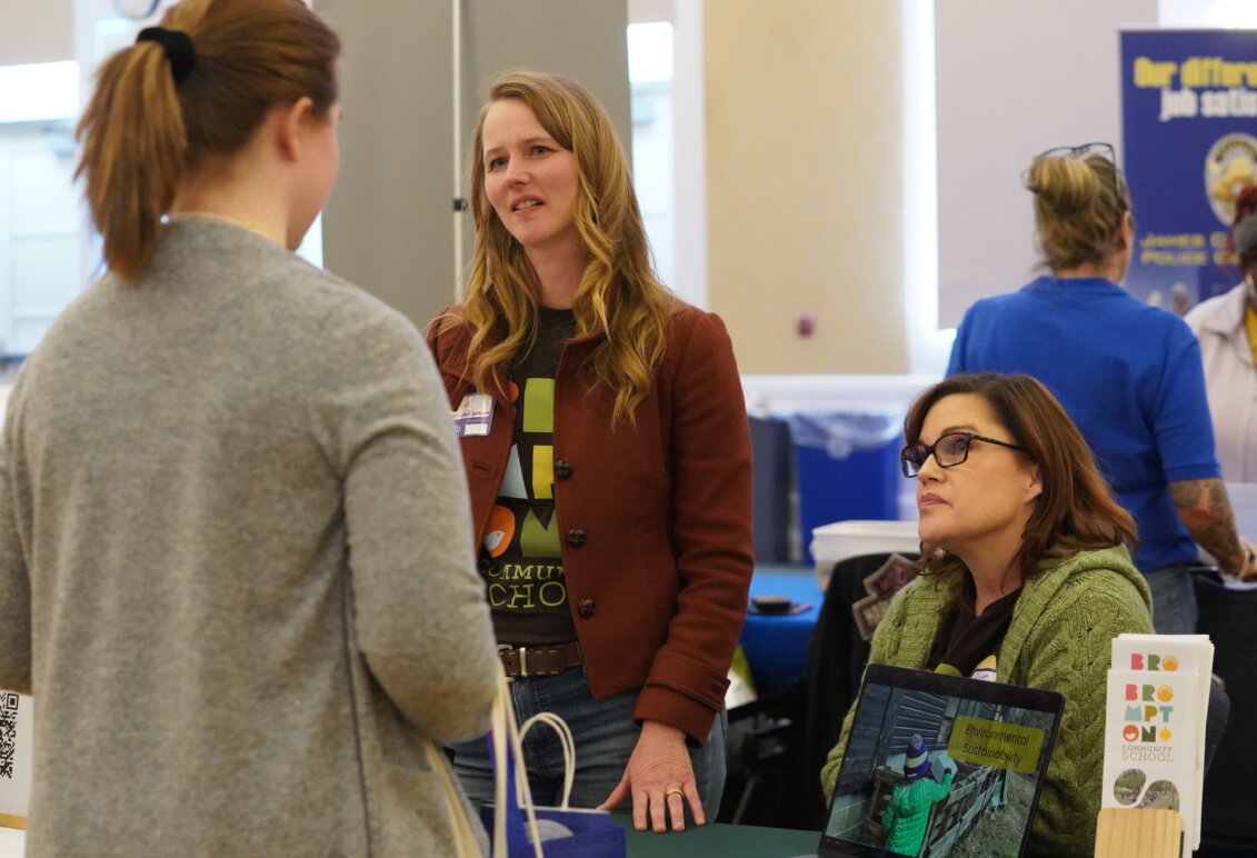 Three women talk during a career fair