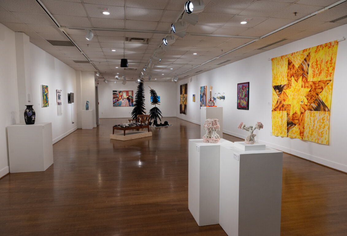Works of art displayed on walls and sculpture situated around a room