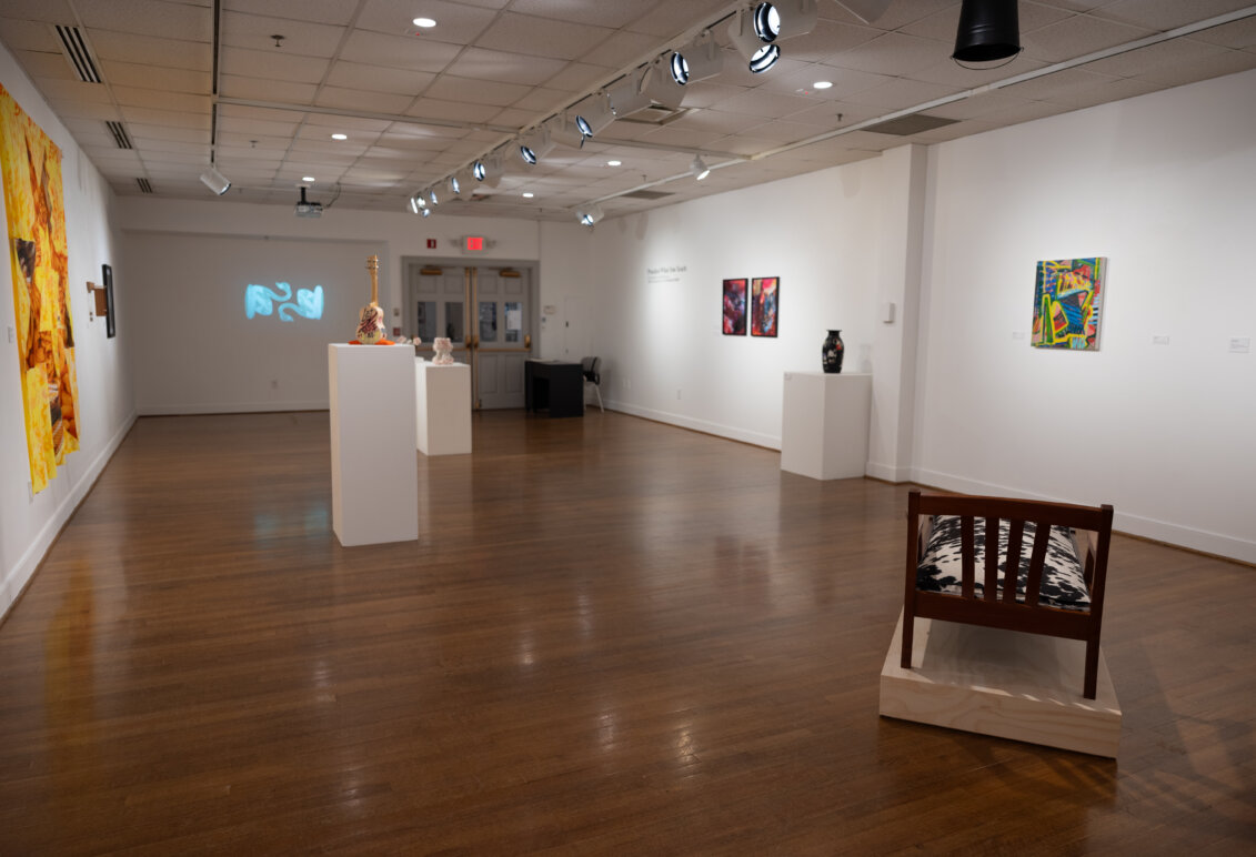 Works of art displayed on walls and sculpture situated around a room