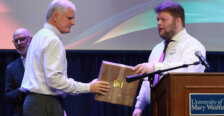 A person accepts an award onstage from another person