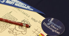 A piece of paper with a maze and other games sits on a table along with a University of Mary Washington sticker and pennant